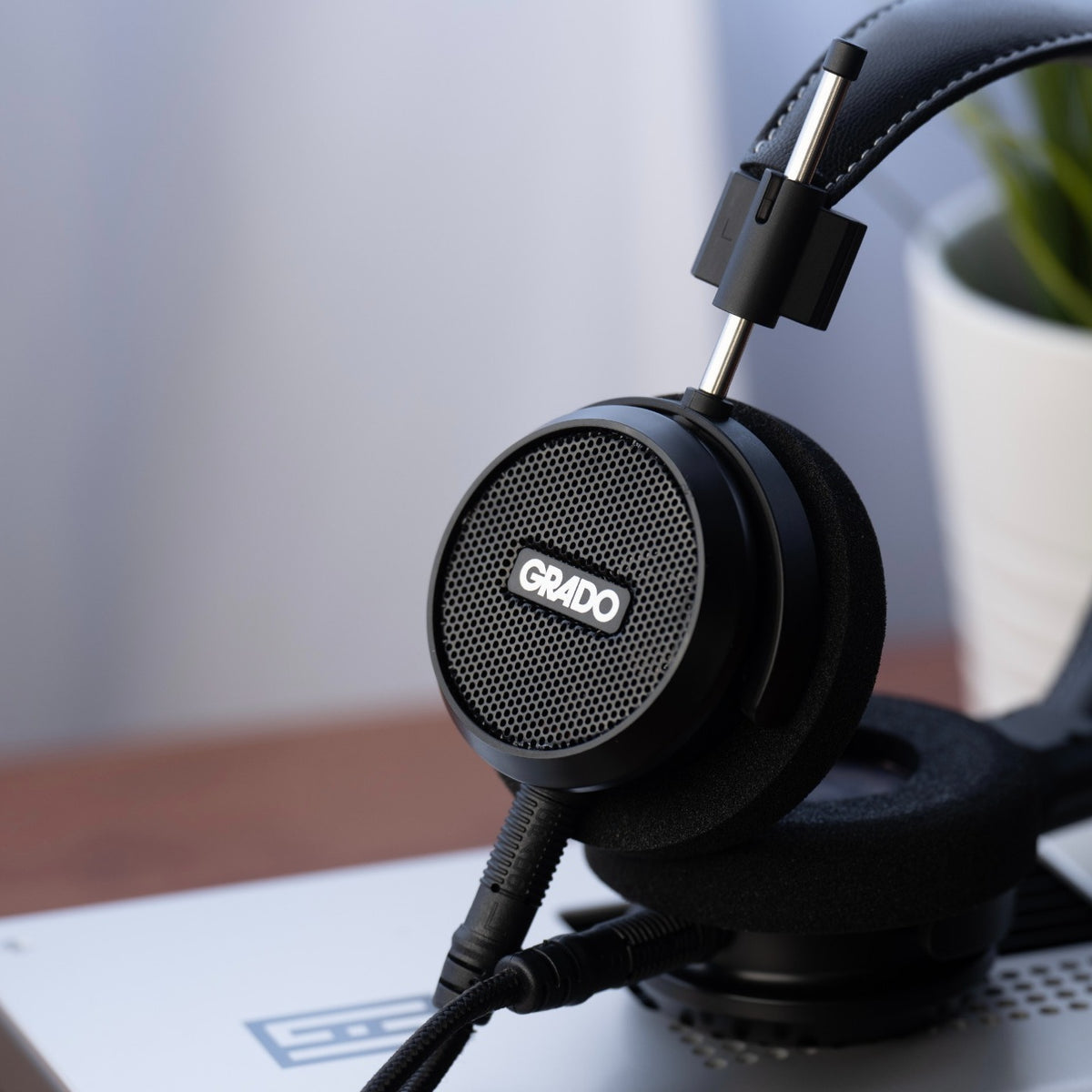 Grado Signature S150 headphones resting on a desktop DAC at home